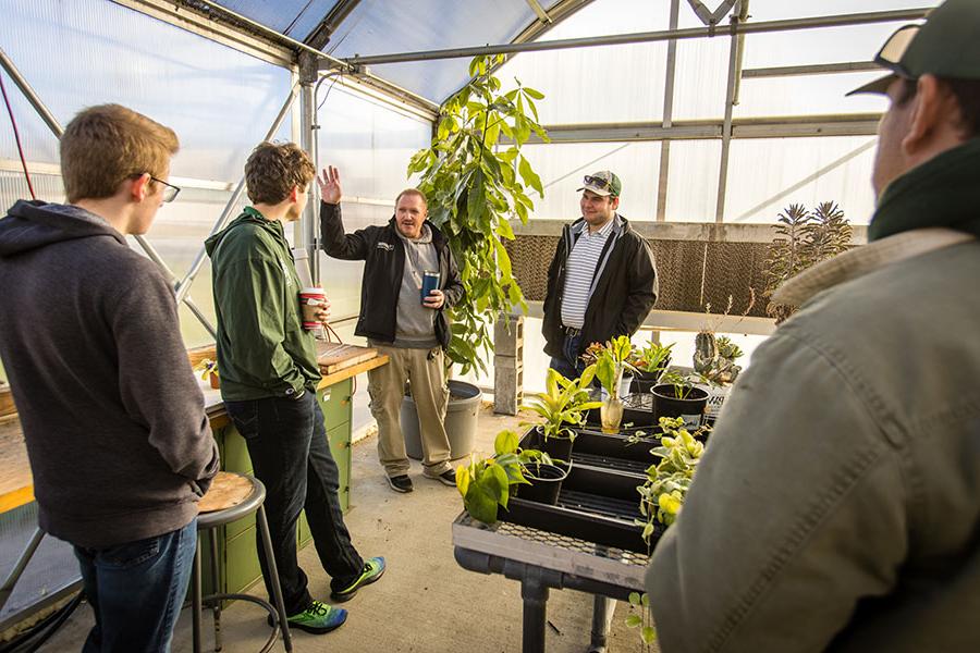 Students in Northwest's Internet of Things course talk with Bryan Freemyer, 这所大学的植物专家, about the sensor platform they set up inside the Horticulture Complex to better monitor plant life there. (Photos by Lauren Adams/<a href='http://enlg.litpliant.net'>全国网赌正规平台</a>)